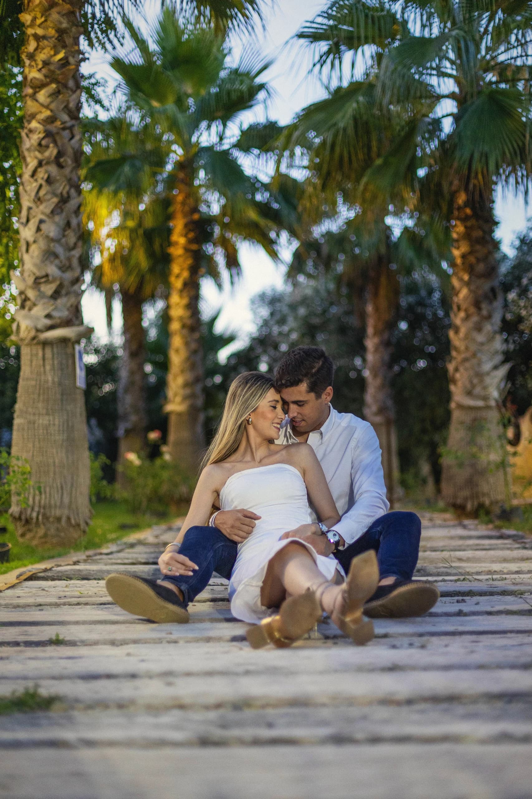La pareja sentada entre palmeras