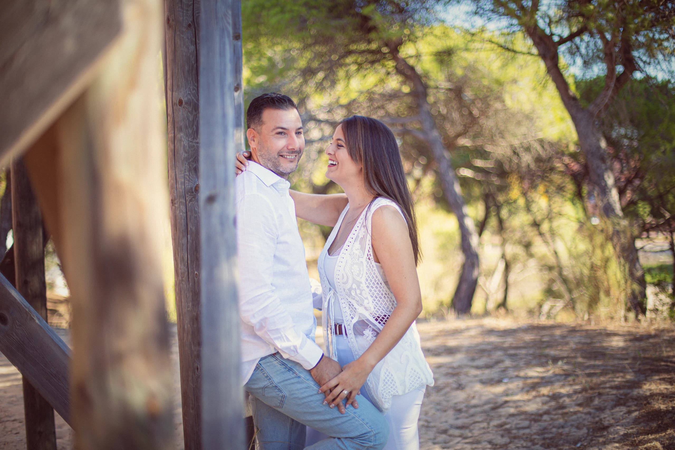 Los dos vestidos de blanco entre las vigas de madera del pinar