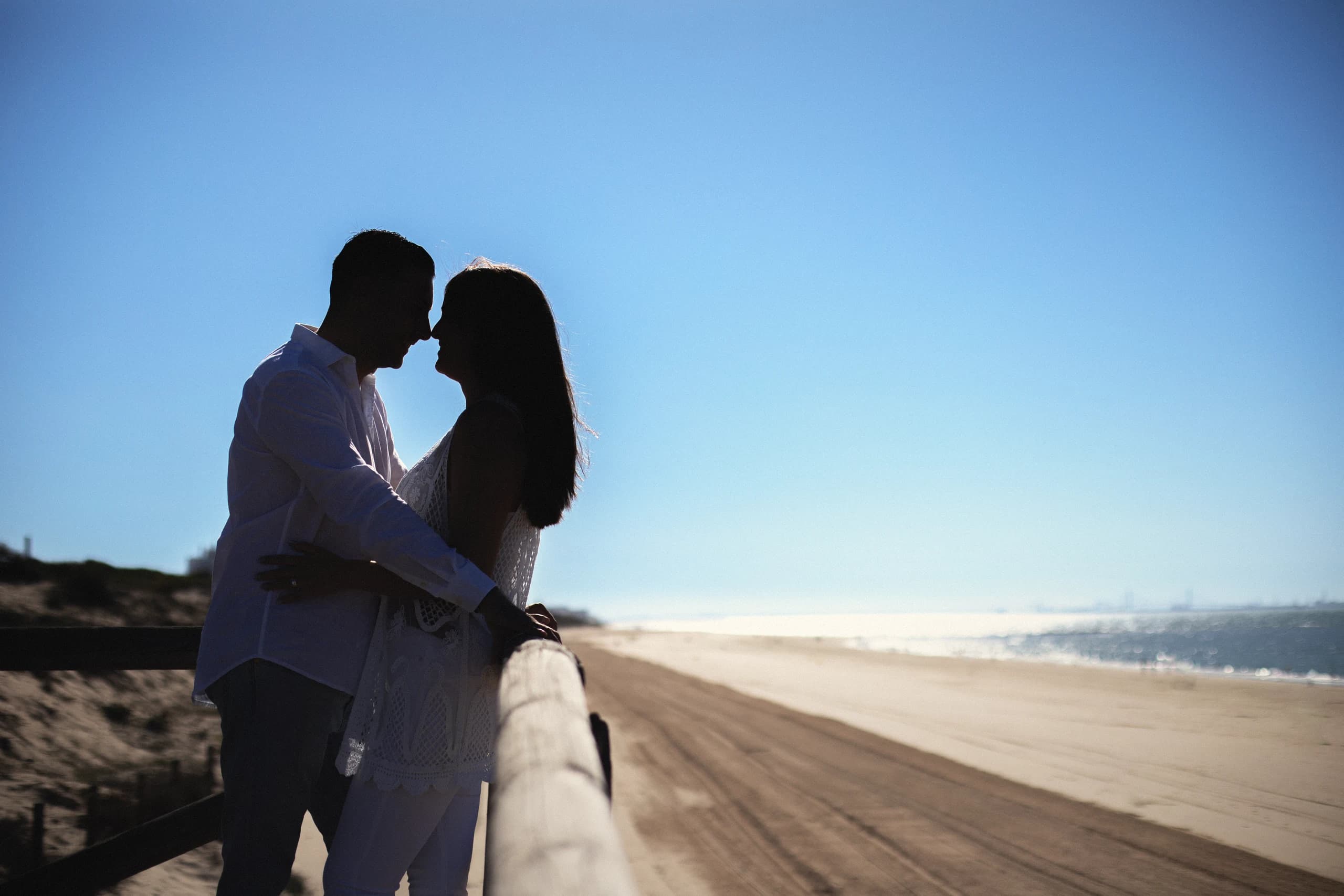 Silueta de la pareja a contraluz sobre el paseo de la playa