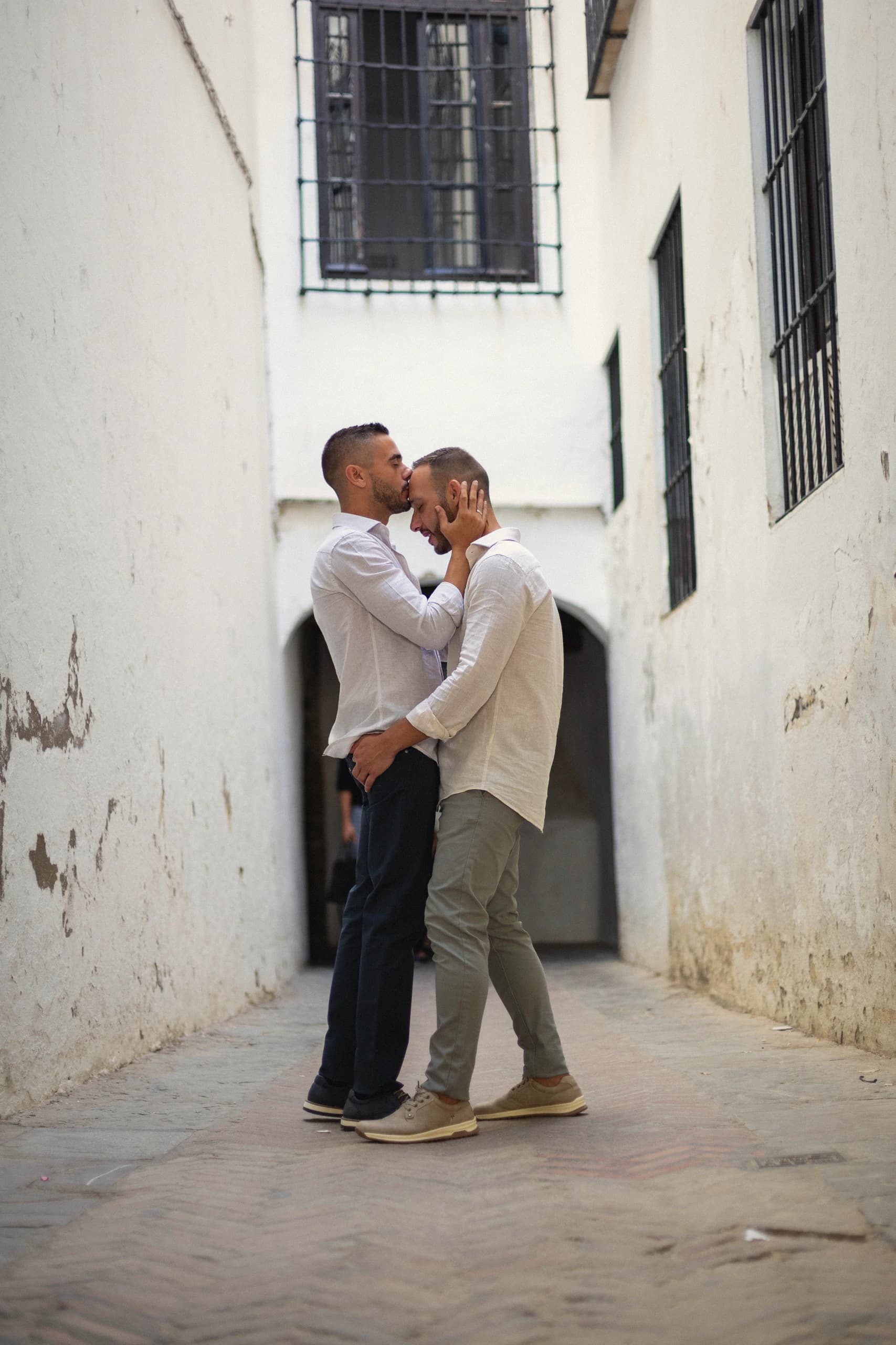 Abrazo en un pasaje estrecho de paredes blancas