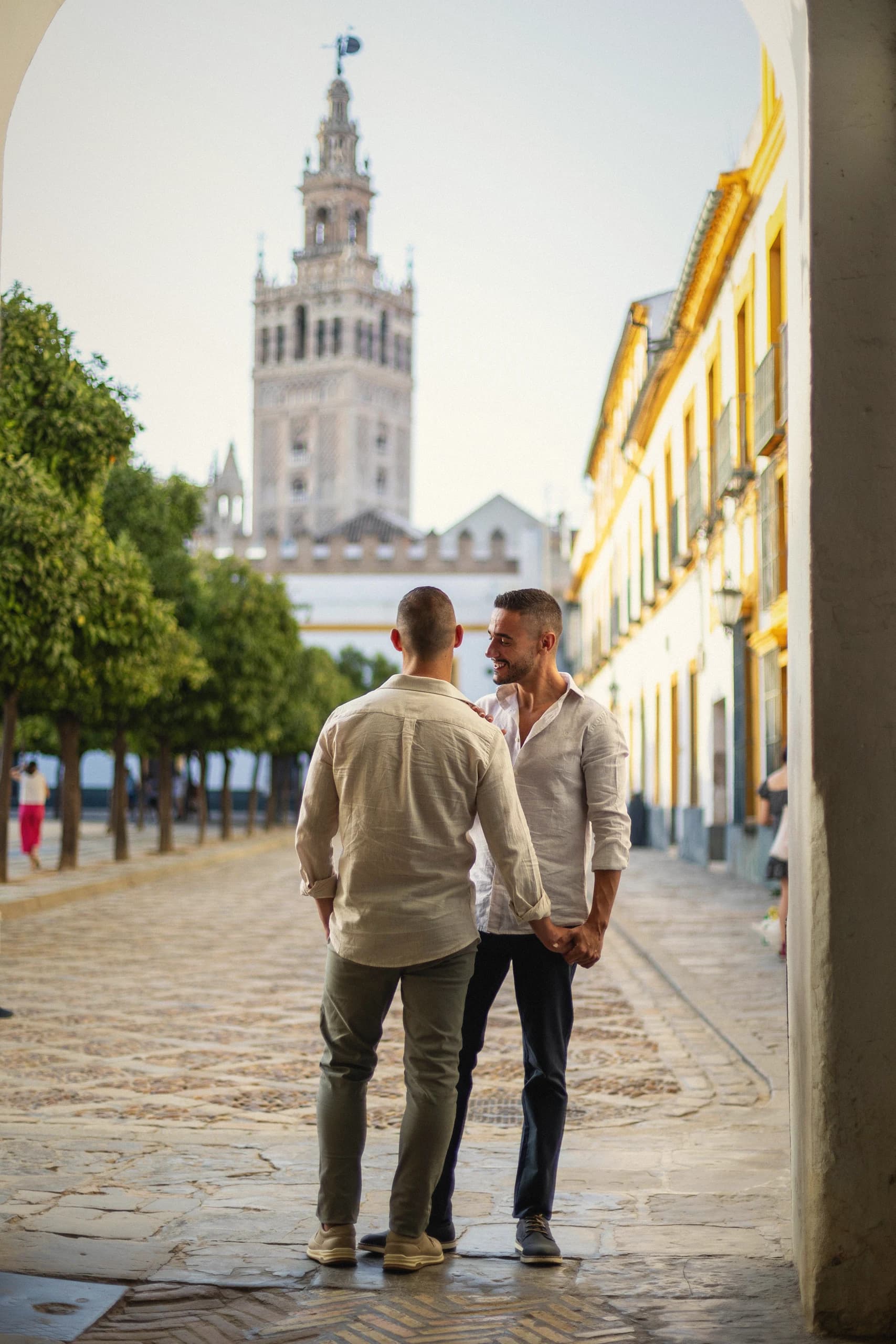 Los dos de espaldas bajo el arco del Patio de Banderas con la Giralda al fondo
