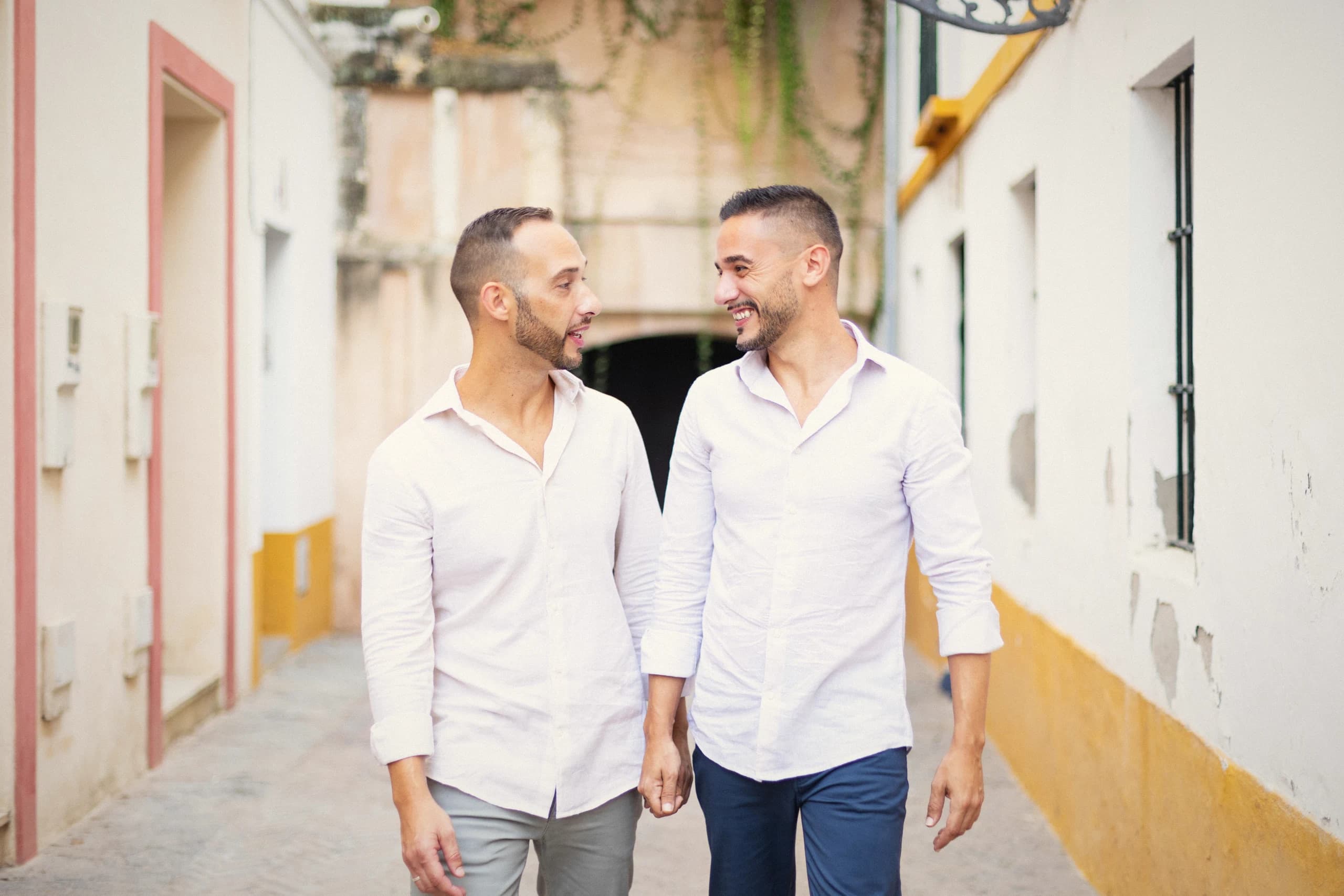 Caminando juntos por una calle de fachadas rosas y amarillas del barrio