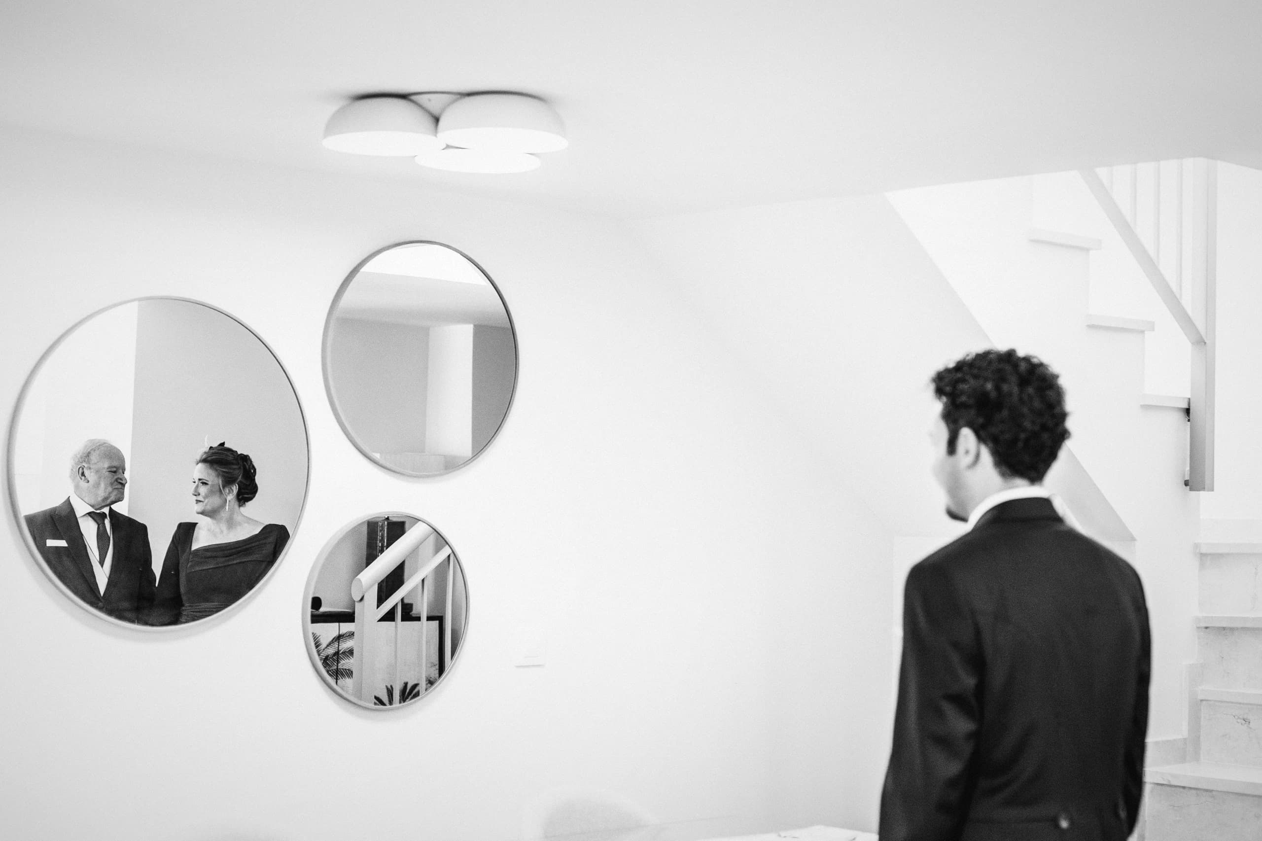 El novio reflejado en los espejos redondos del recibidor