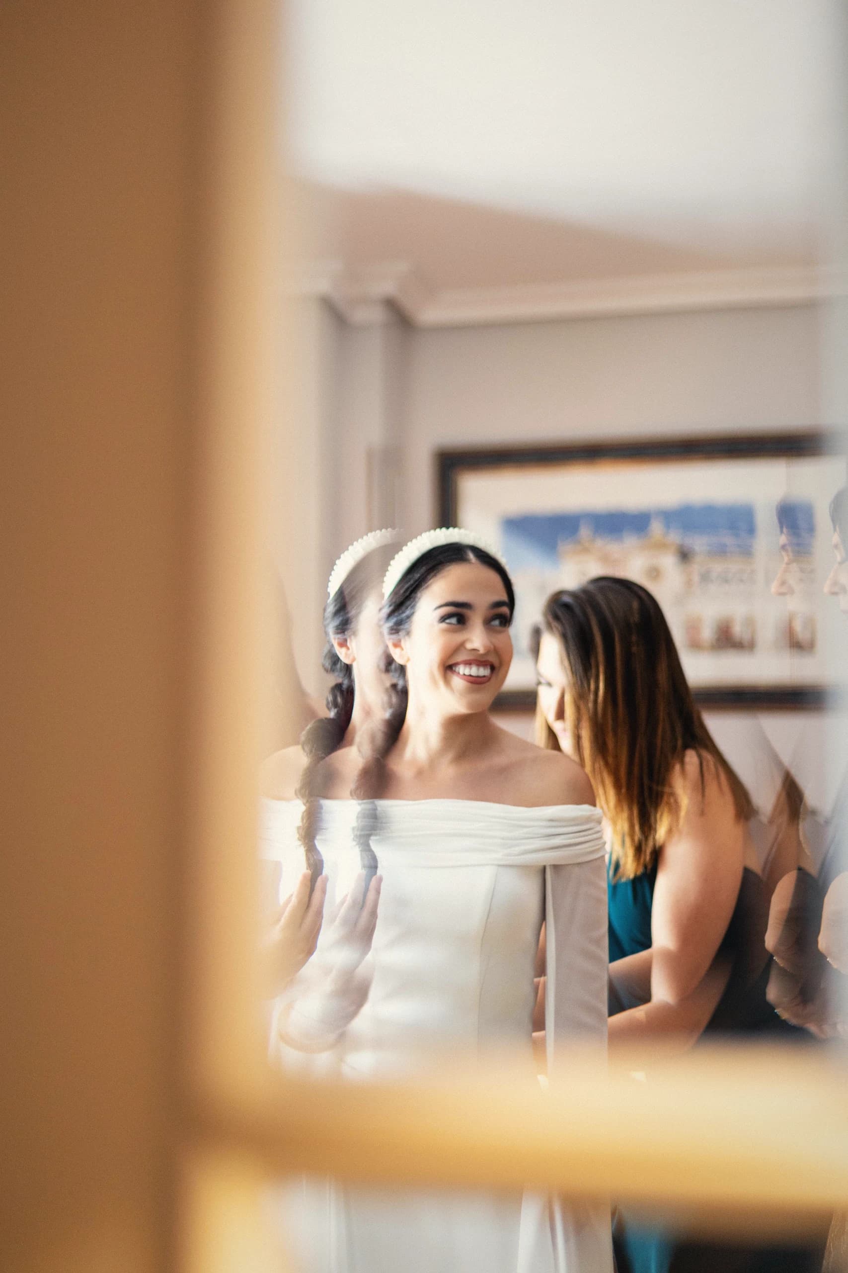 La novia y una invitada asomadas a la ventana