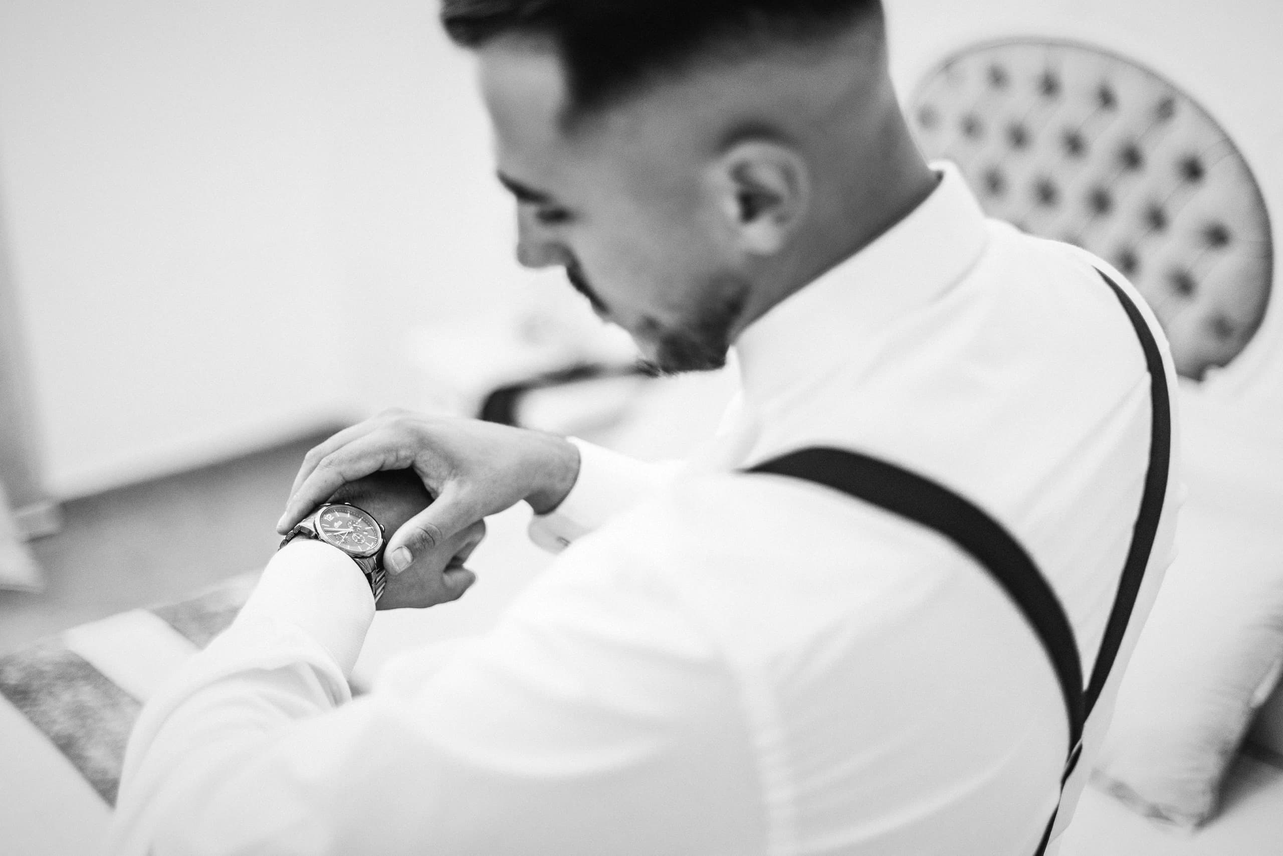 El novio abrochándose el reloj, en blanco y negro