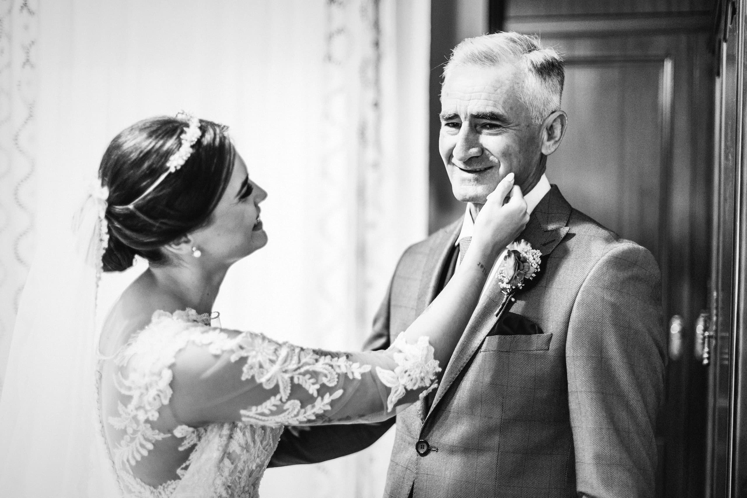 La novia colocándole la flor a su padre