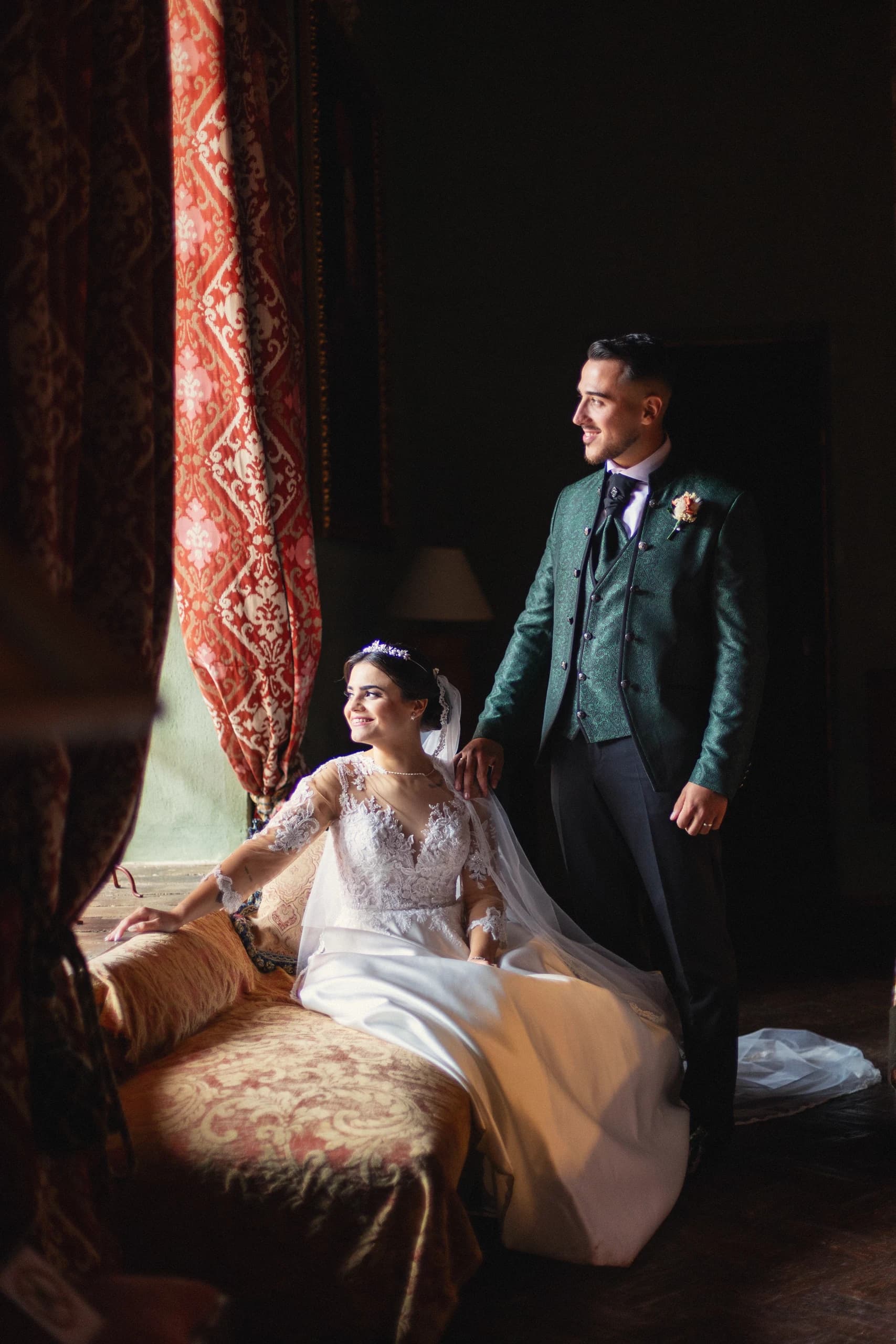 Los novios en el salón de cortinas rojas