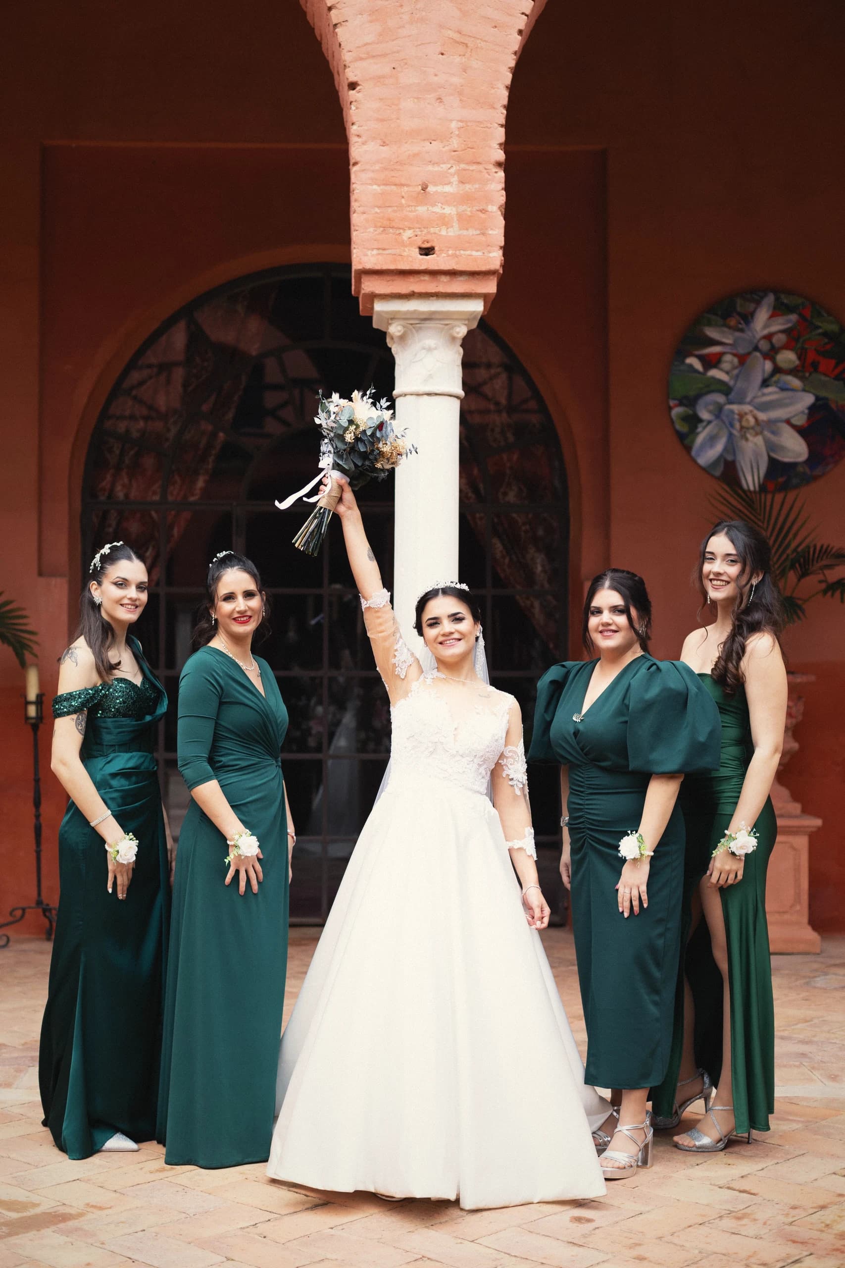 La novia con el ramo en alto y sus damas de verde