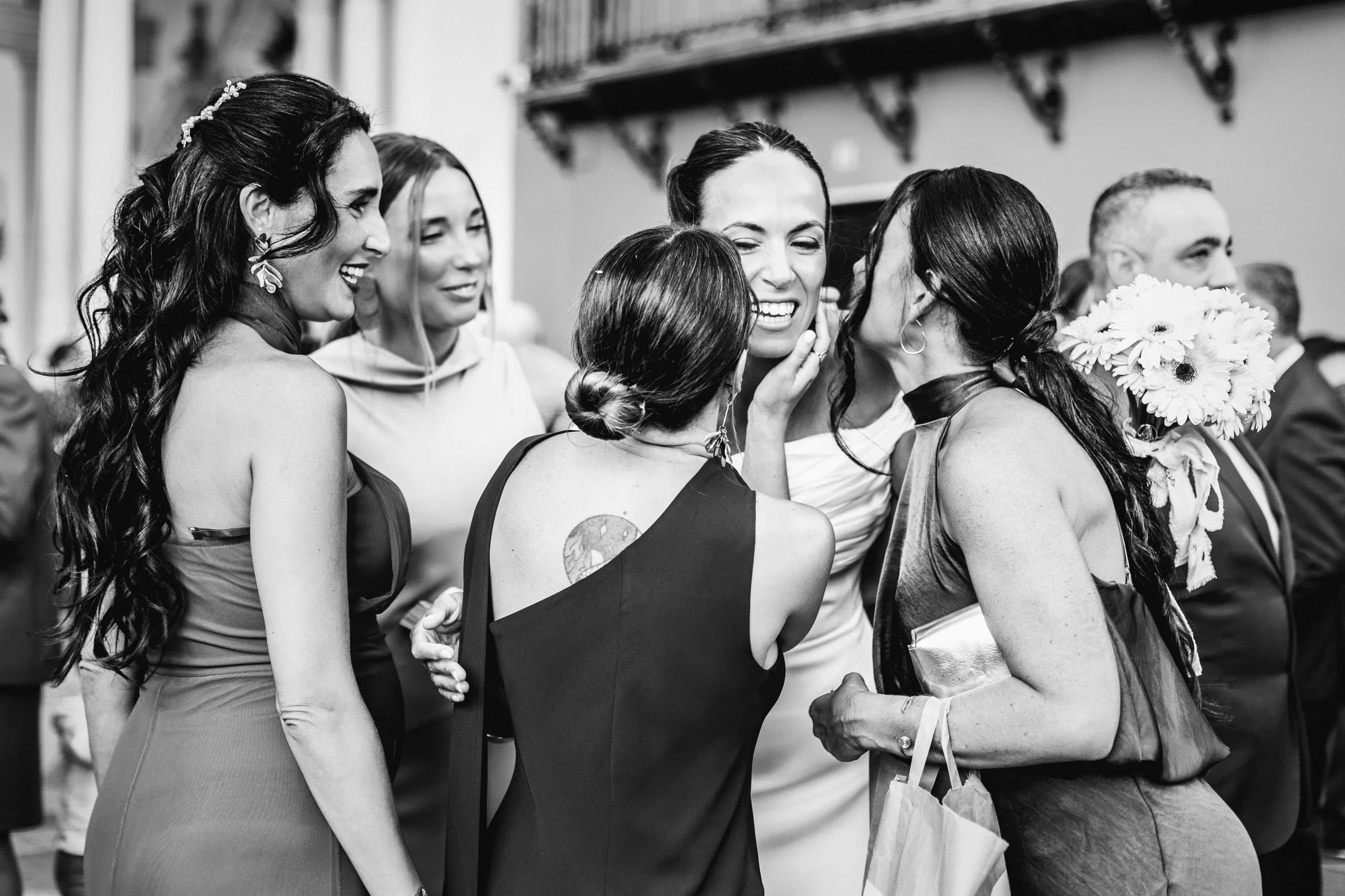 Las amigas abrazando a la novia, en blanco y negro