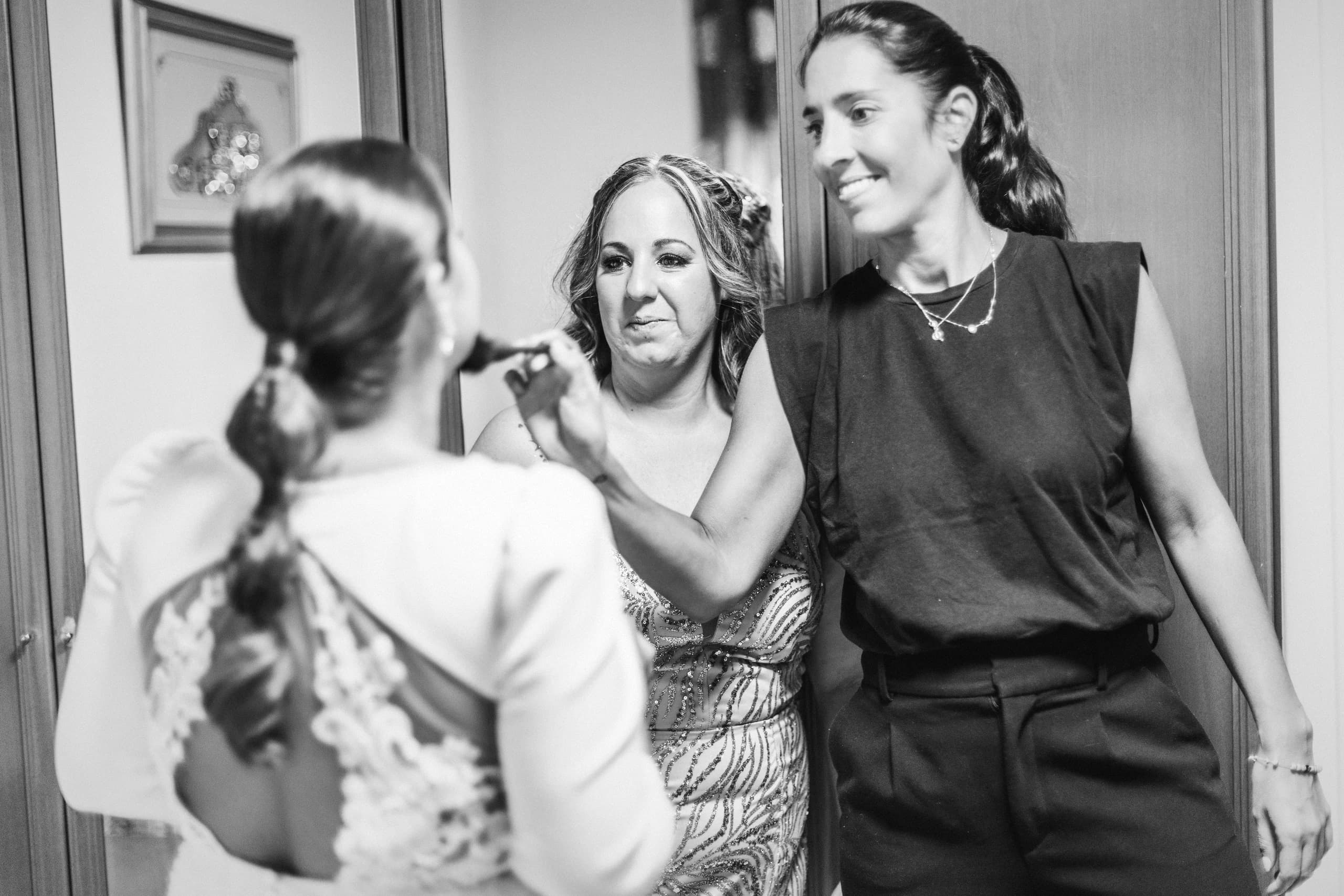 La novia durante el maquillaje con su madre, en blanco y negro