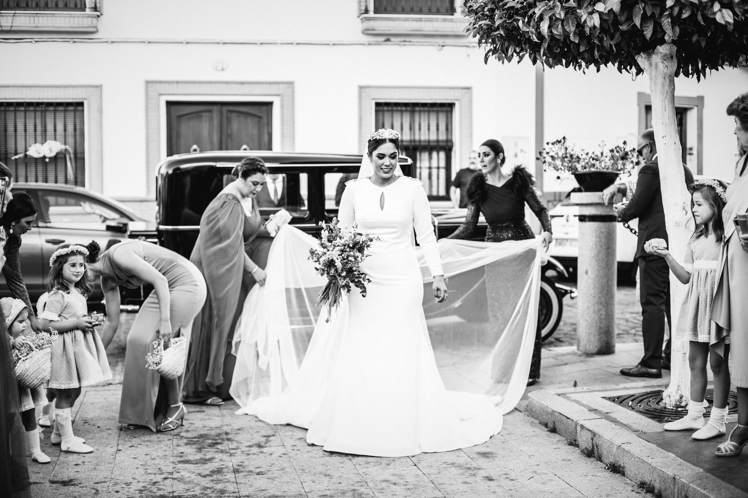 La novia llegando a la iglesia con el velo al viento, en blanco y negro