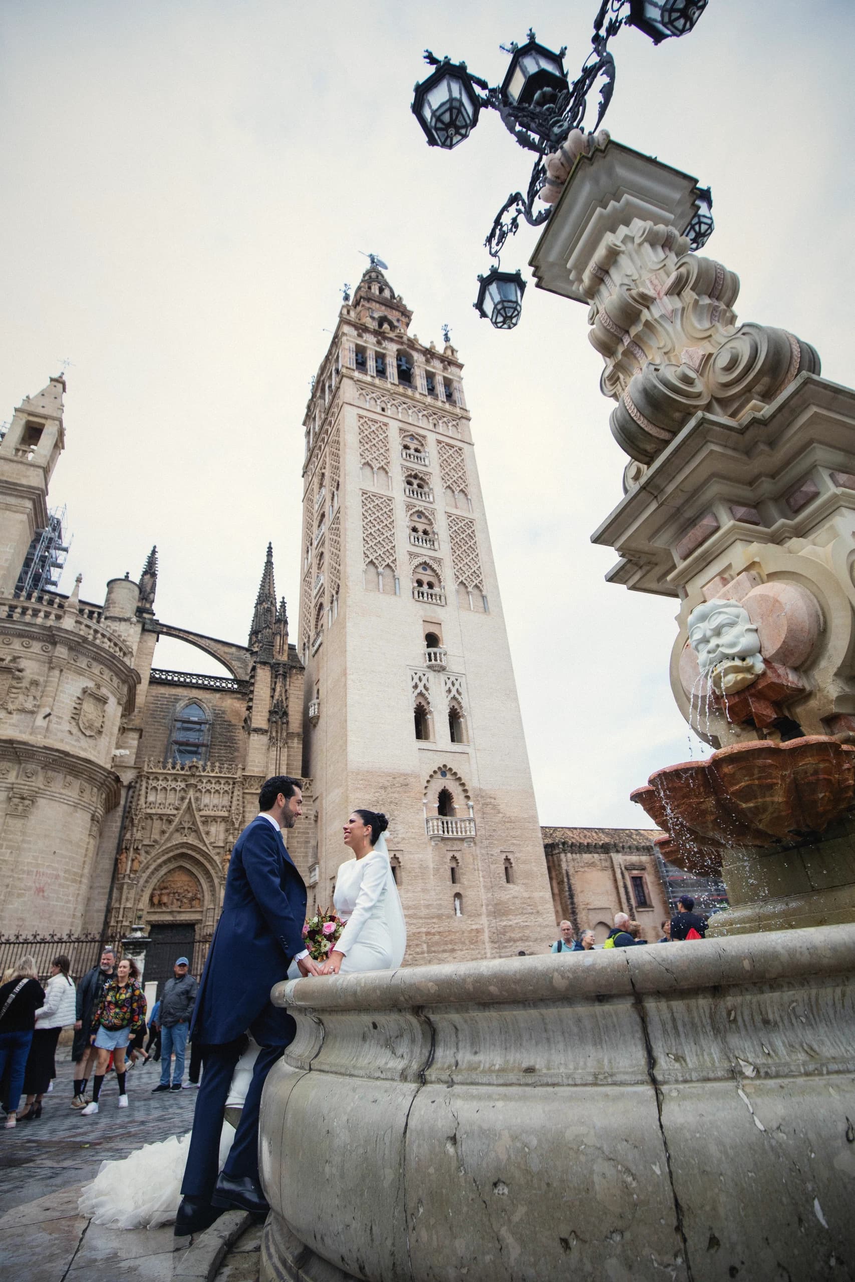 La novia sentada en la fuente con la Giralda detrás